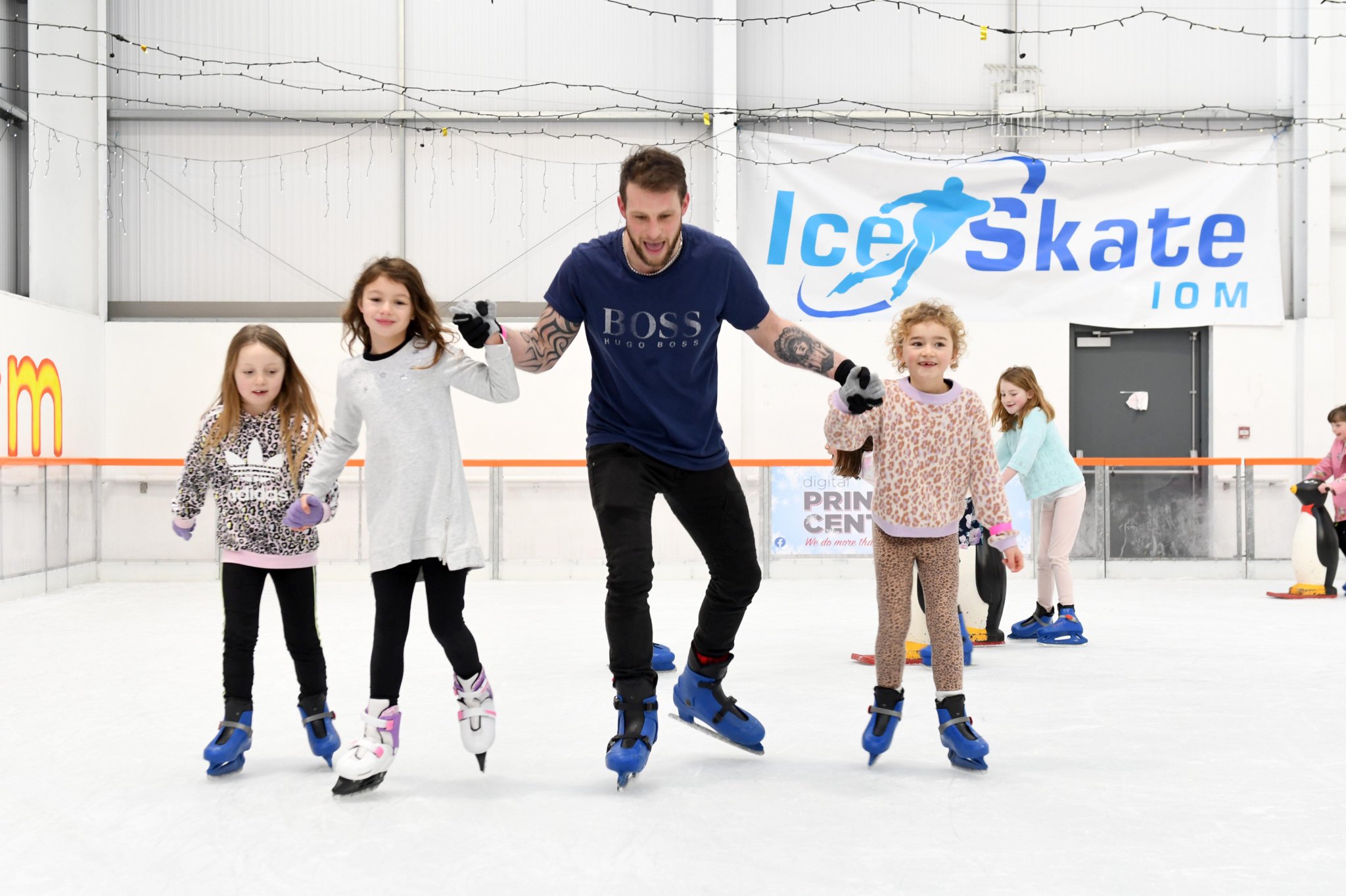 Neeve, Kaiya, Kaiya’s dad Chris and Esme hold hands as they take to the ice rink together