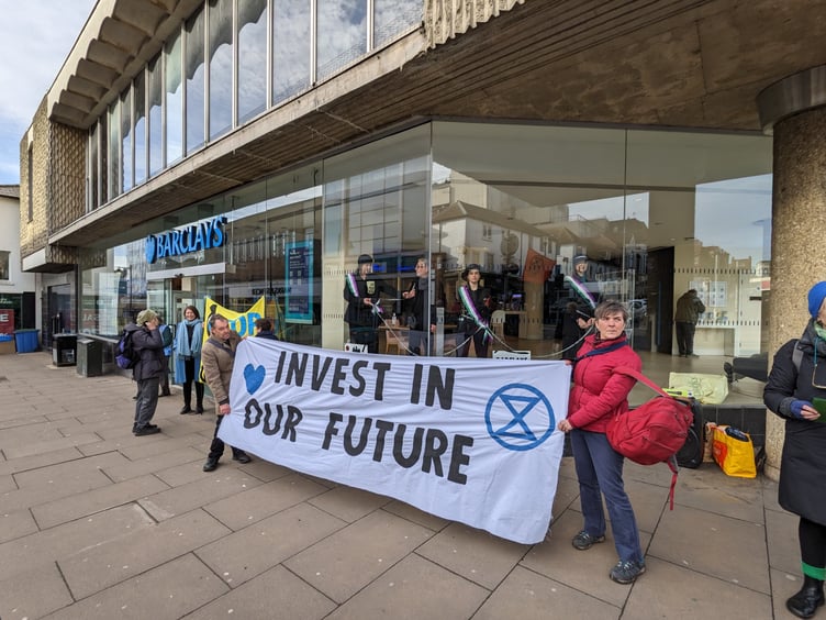 Three women, dressed as suffragettes, chained themselves together in the window of Barclays in Guildford