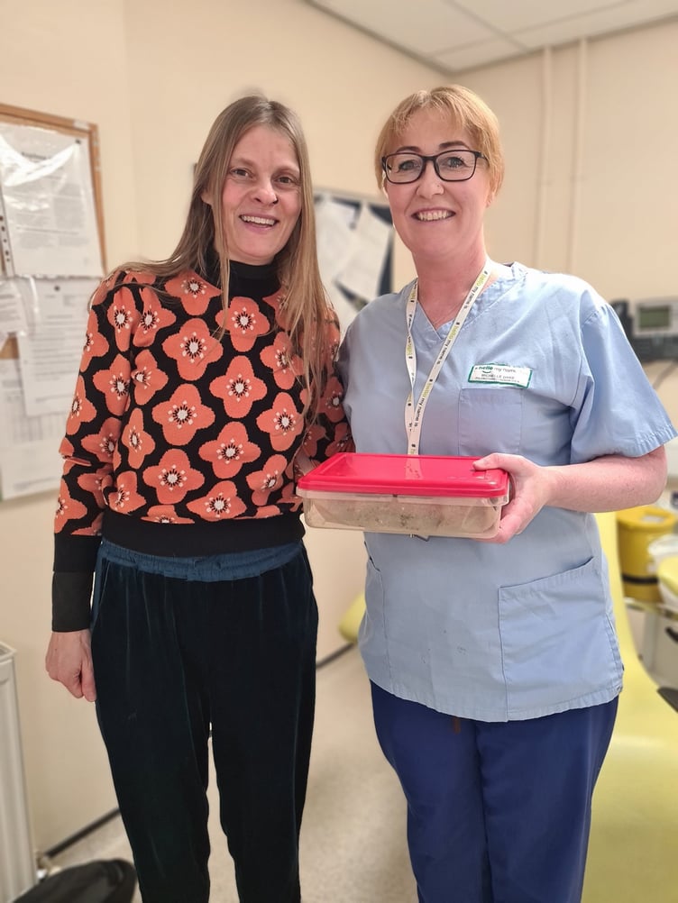 Jackie Morrey-Grace presents Michelle Dyke from Ramsey Cottage Hospital Blood Clinic with a cake for the #BeKind2023 Without Wings campaign
