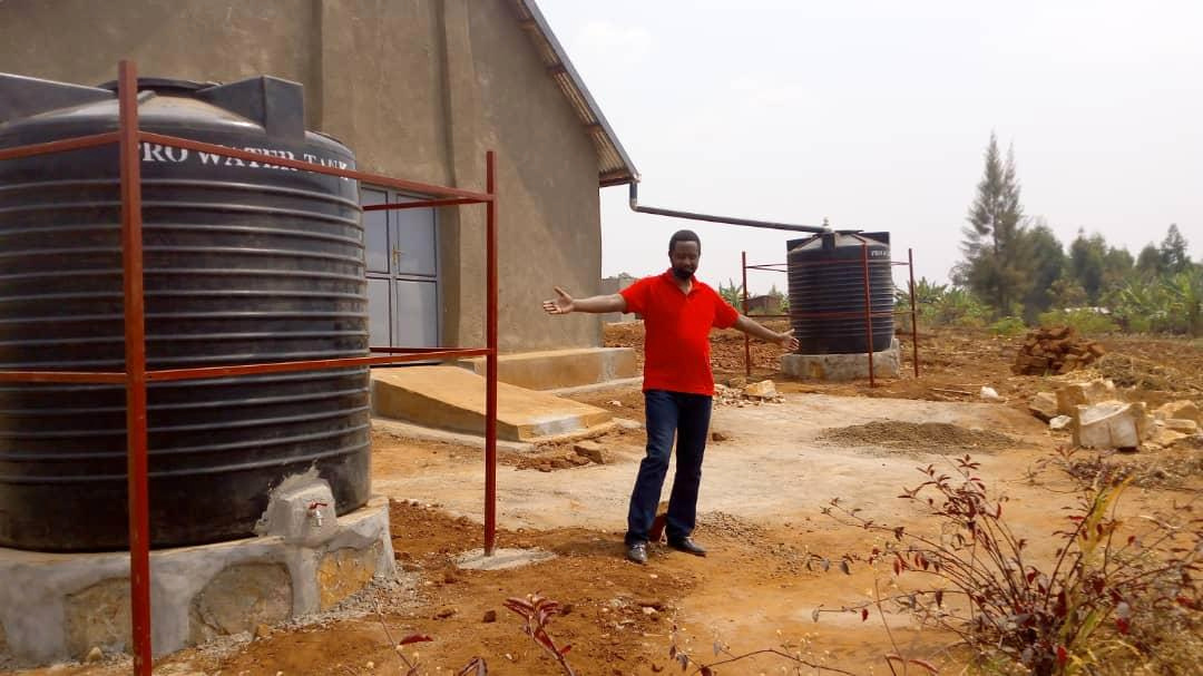 Bishop Enock with one of the new water harvesting tanks
