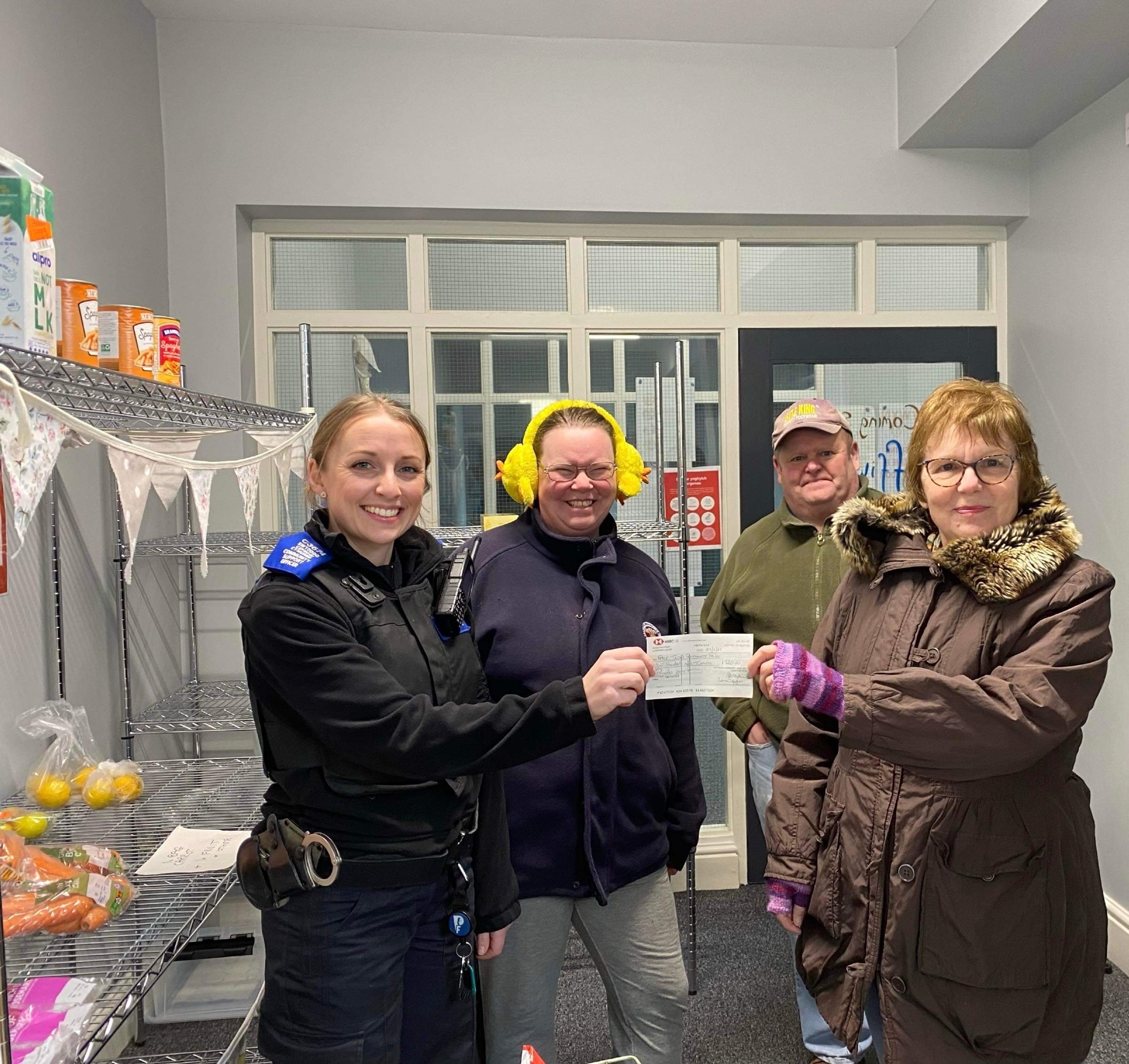 PCSO Sandie Williams presents cheques to representatives of Ffrij Tywyn Community Fridge (left) and St Cadfan’s Church (right)