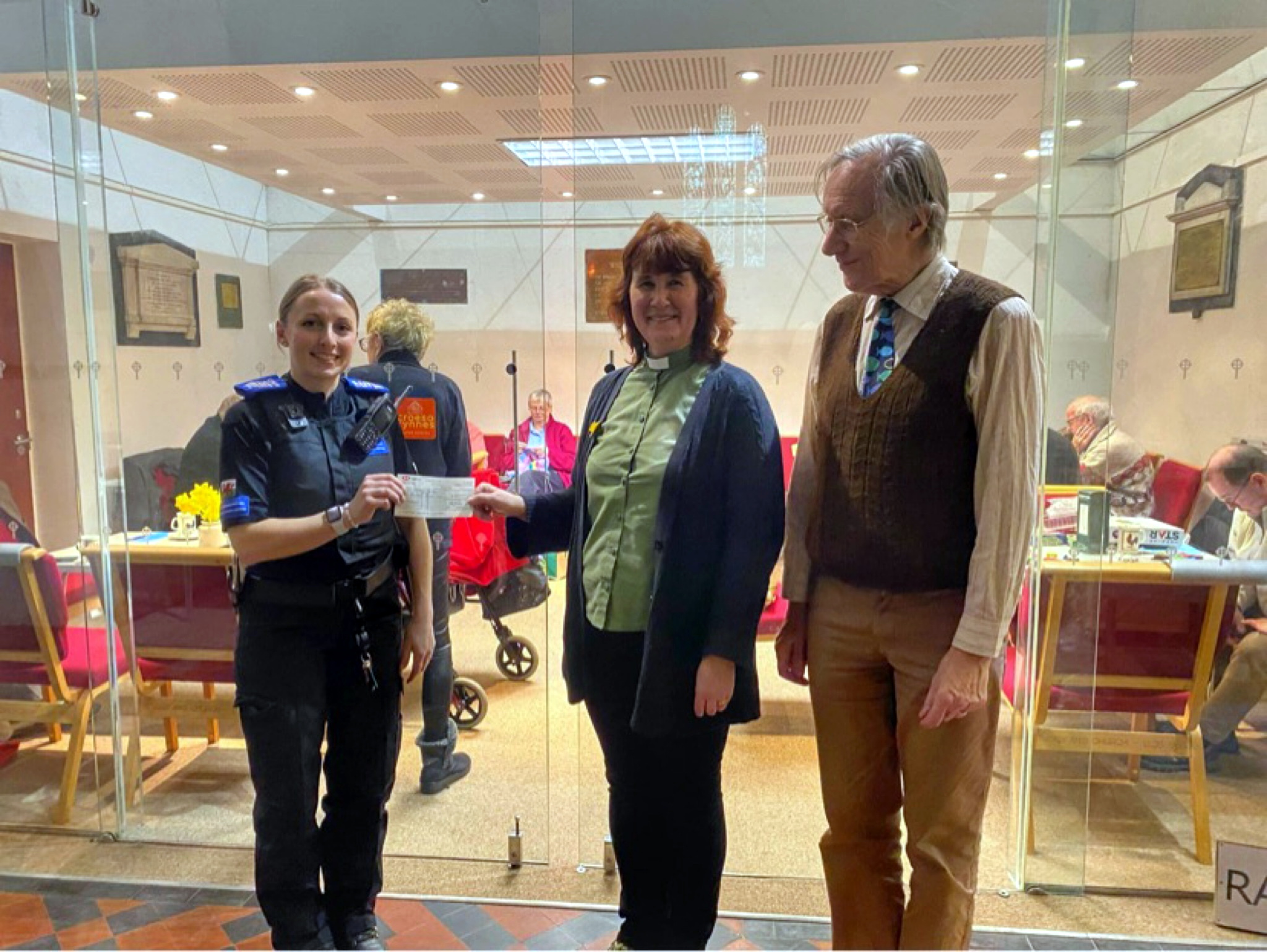 PCSO Sandie Williams presents cheques to representatives of Ffrij Tywyn Community Fridge (left) and St Cadfan’s Church (right)