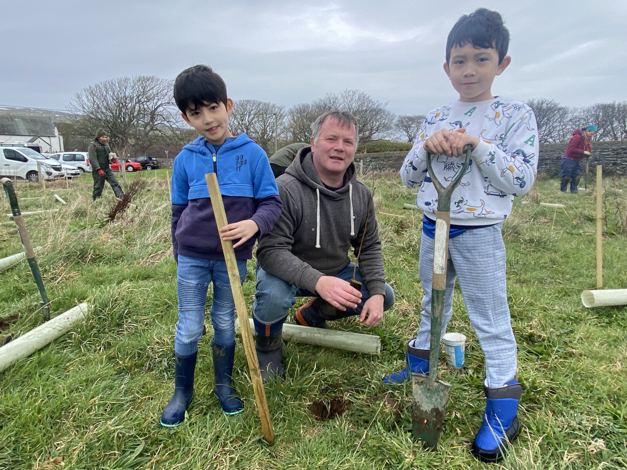 Stuart Owens with Jacob and Josh plant an alder sapling
