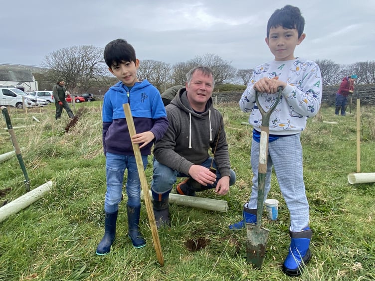 Stuart Owens with Jacob and Josh plant an alder sapling