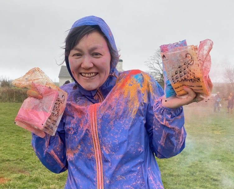 Justine Howard holds up her bags of coloured powders