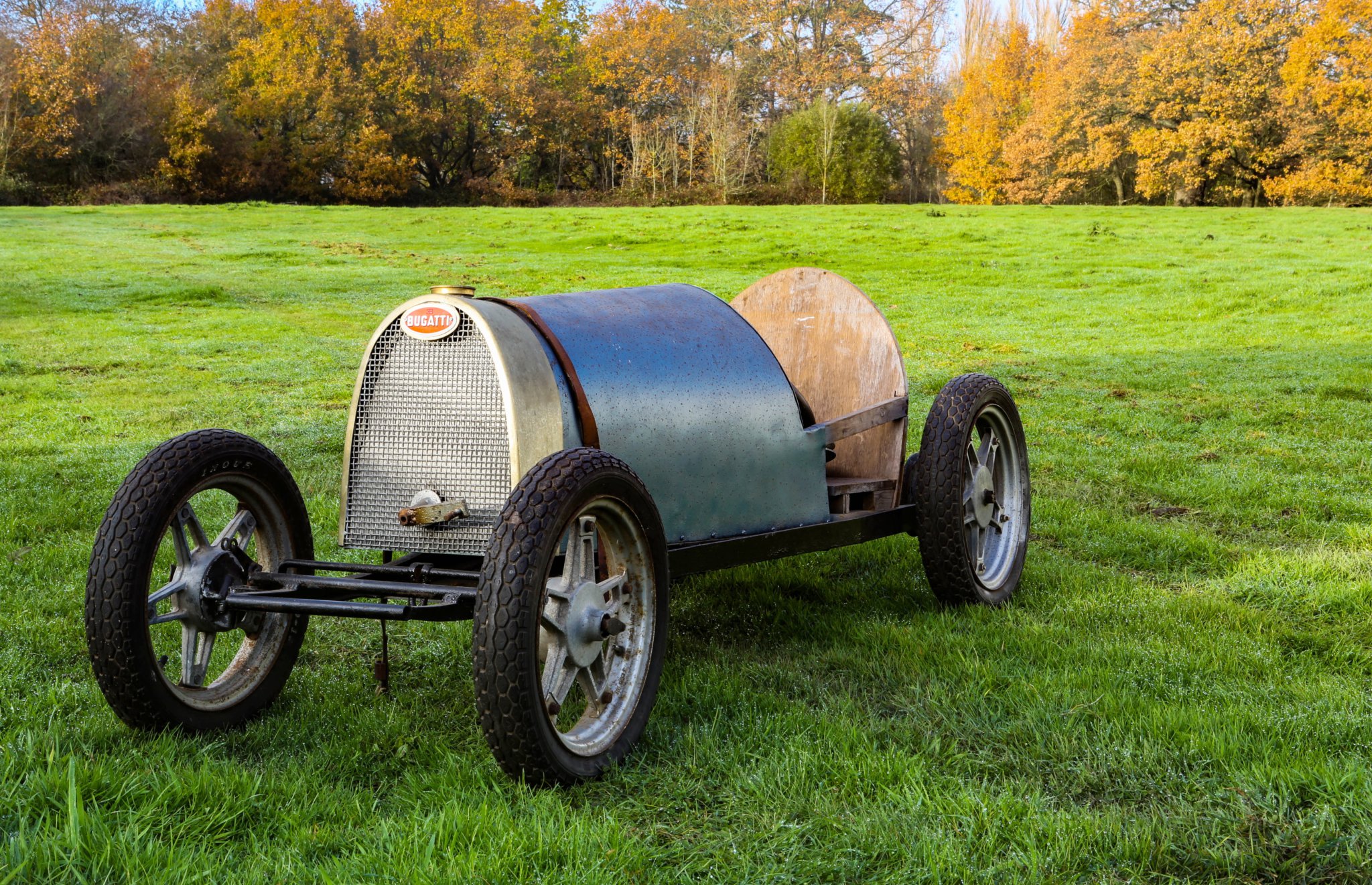 A pedal car with alloy wheels and a Bugatti nameplate on the front.