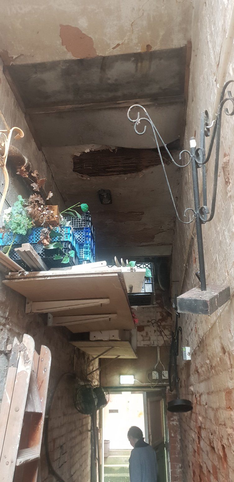 Part of the floor of a building over a private alleyway beside shops in Cornhill, Wellington, can be seen to have given way.
