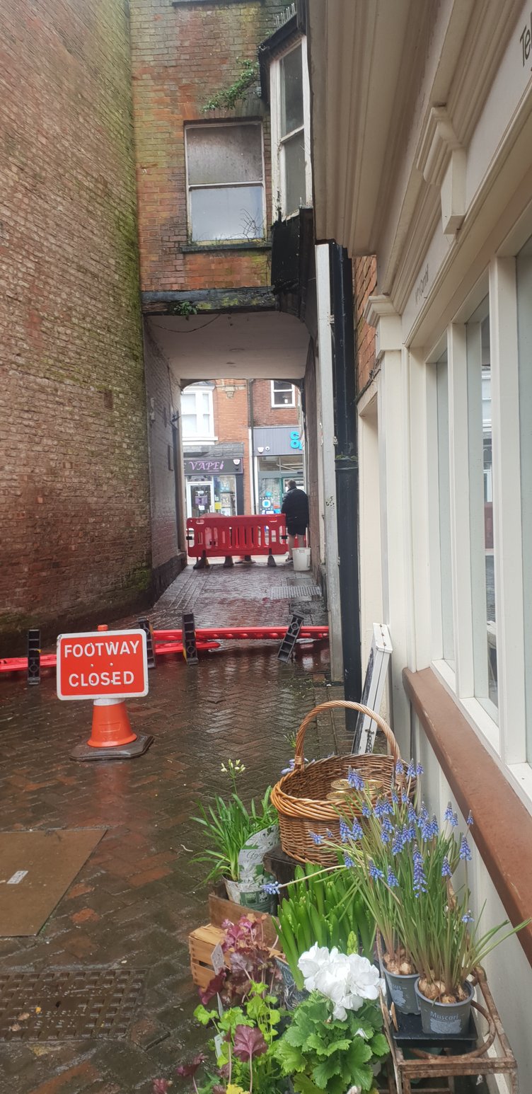 A pedestrian can be seen pushing through safety barriers which have been used to close Cornhill, Wellington.
