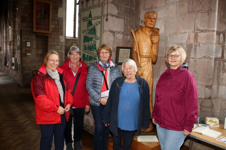 The German visitors, some of whom are pictured, admired the statue of Wynfrith, pictured with one of the Crediton Parish Church hosts. AQ 0250