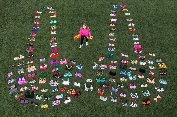 SUPPORT – Walk the Walk staff member Rachael Hopson arranges 137 brightly decorated bras to celebrate the breast cancer charity raising £137m.