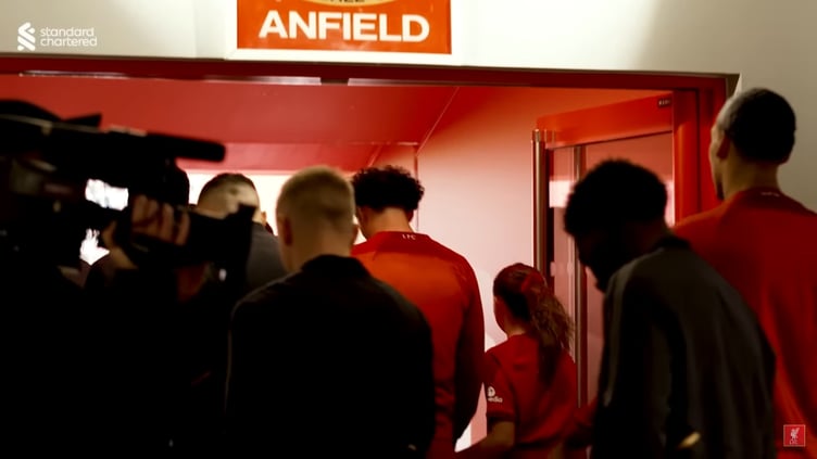 Esme and Curtis as they walk out of the tunnel underneath the famous 'This is Anfield' sign