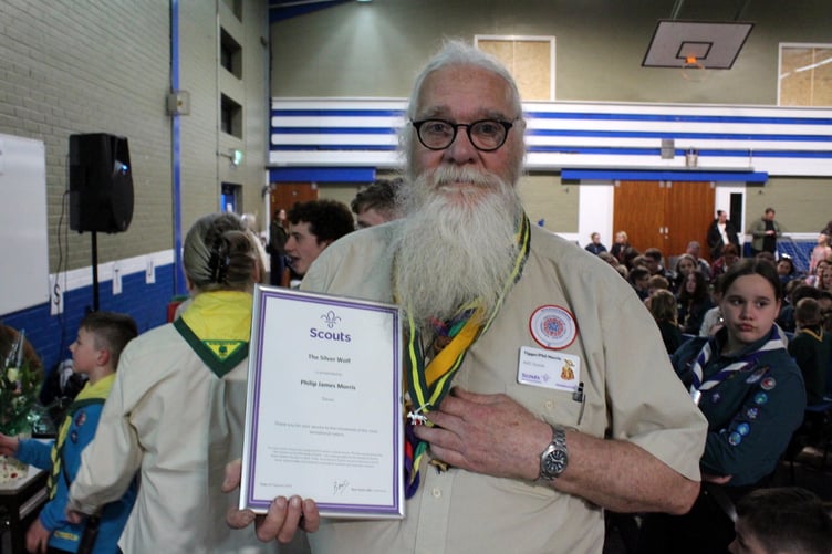 Philip Morris shows his certificate and the Silver Wolf he now wears. SR 7437