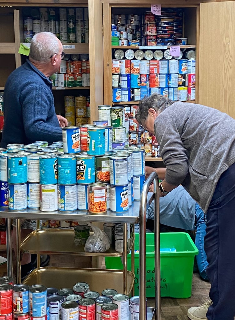Local Pantry anniversary volunteers cleaning the tinnned goods cupboards.