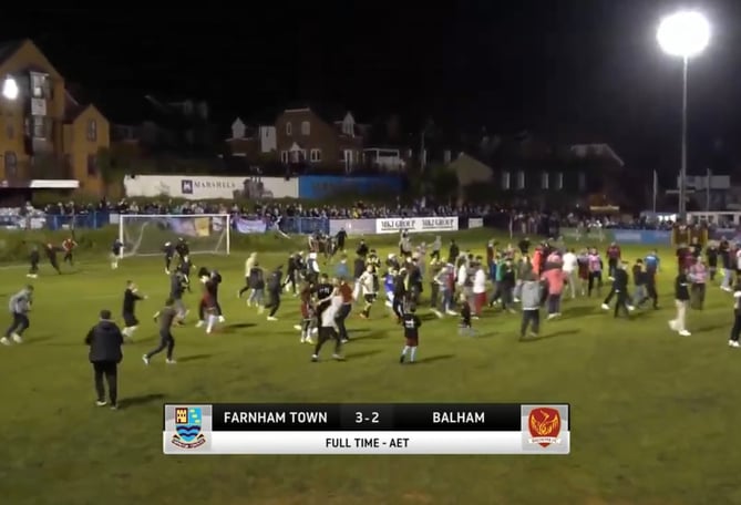 The crowd rush onto the pitch after Farnham Town seal a memorable cup win at the Memorial Ground