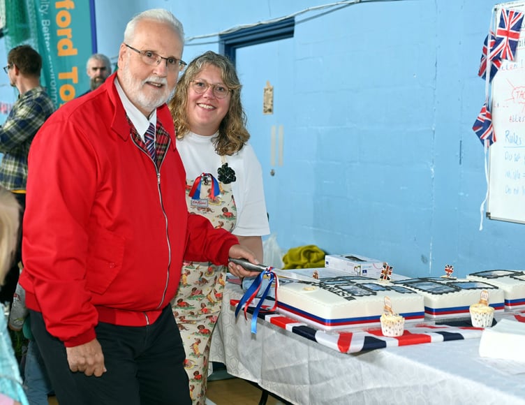 Robert Rothchell (Camelford Town Mayor) as the honoiur of cutting the Coronation Cake lookling on is Kirsty Ferguson who made the delcious cake