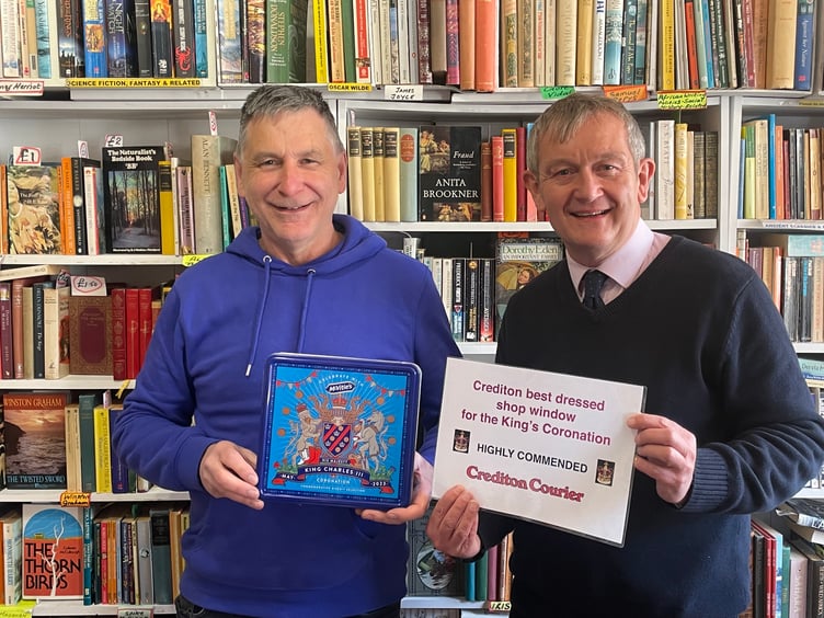 Alan Quick, Editor, ‘Crediton Courier’, right, presents a Highly Commended certificate and tin of biscuits to Jim Thatcher of Once Read Book Shop for his window display. AQ 8892 3
