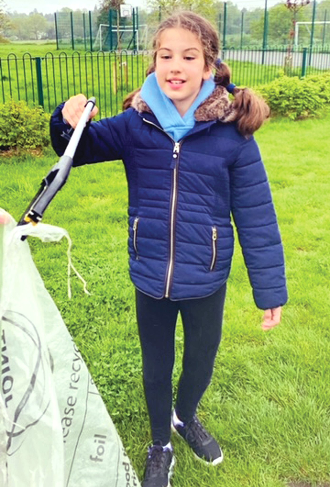 CLEANING UP – Juliet Tudoran collecting litter and toting the sack she filled with rubbish.