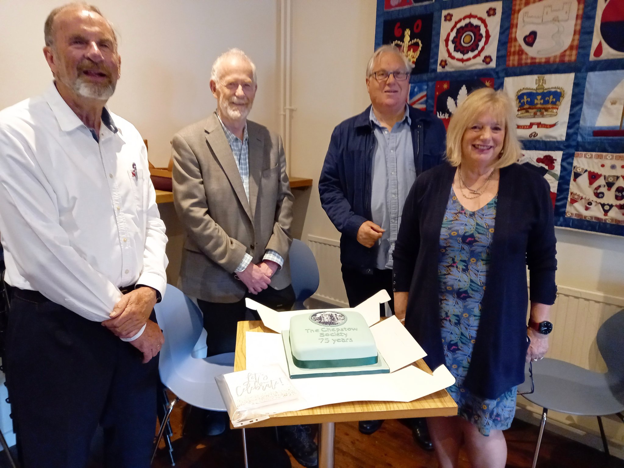 n Chepstow Society President Keith James, Chair Guy Hamilton, Treasurer David Nicholls and Secretary Sallie James with a cake celebrating 75 years of the Chepstow Society.