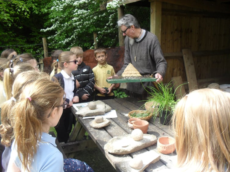 The children are shown a model of an Iron Age hut