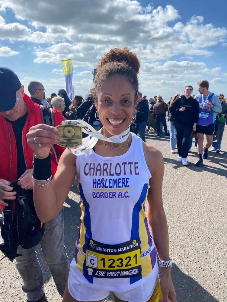 A beaming Charlotte Finden proudly shows off her Brighton Marathon medal