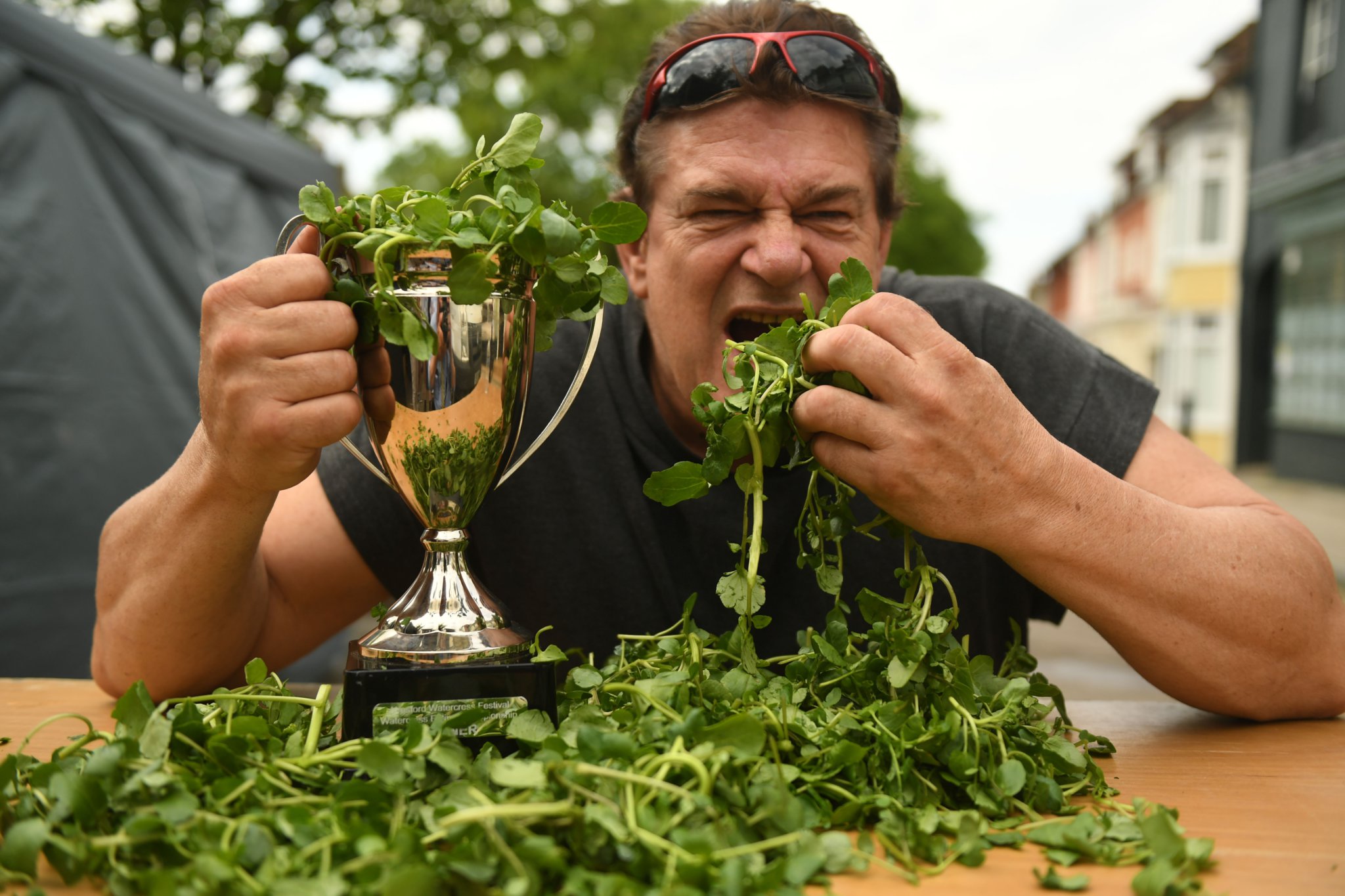<p>Alresford's World Watercress Eating Championship winning Glenn Walsh lifts the trophy of the official Guinness World Record attempt</p>