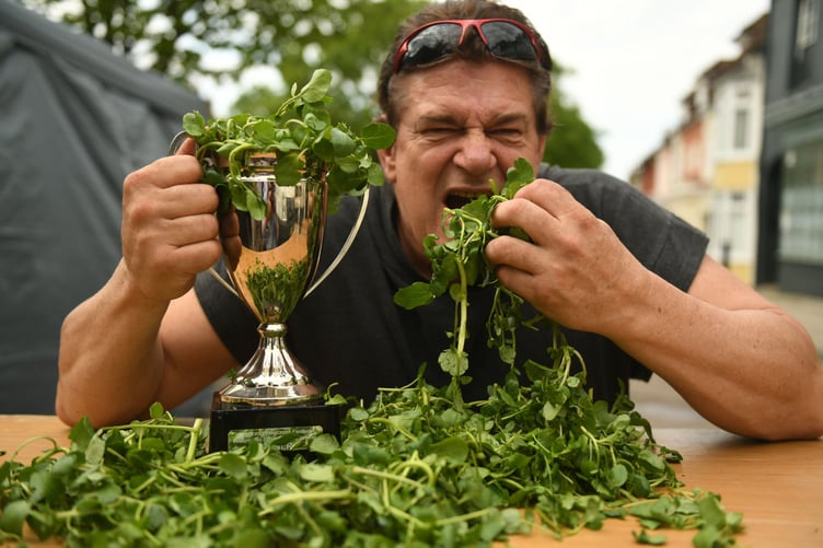 Alresford's World Watercress Eating Championship winning Glenn Walsh lifts the trophy of the official Guinness World Record attempt