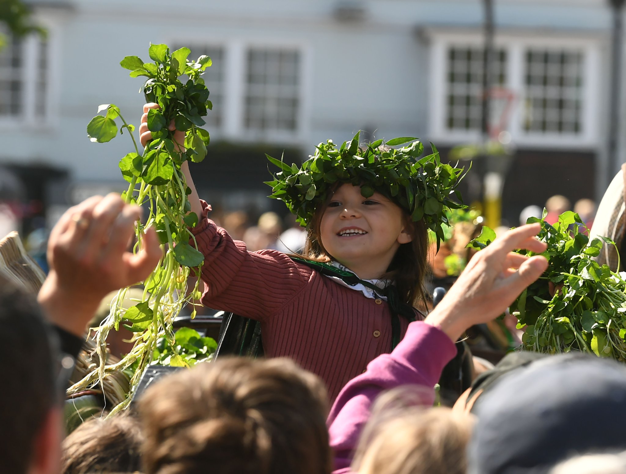 Watercress Queen, Beau Reilly-Taylor and Jack Sims throw cress to the following crowd in the procession