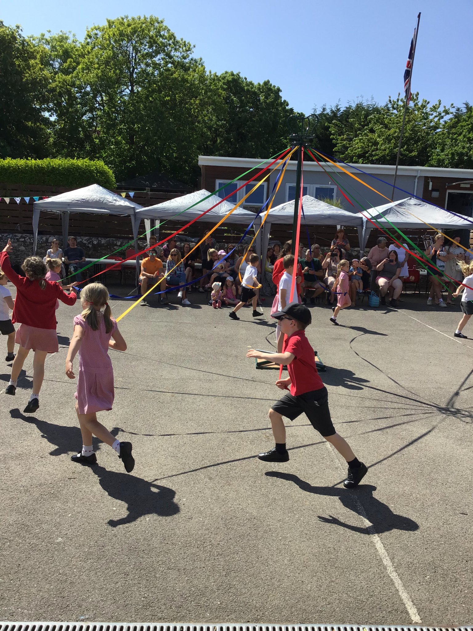 Pictures show the school children, Maypole dancing and, below, the Pre School and celebrating a ‘Good’ Oftsed report
