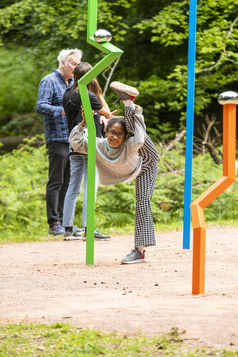 Visitor Aisha Soto doing gymnastics at the sculpture