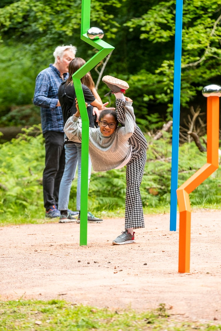 Visitor Aisha Soto doing gymnastics at the sculpture
