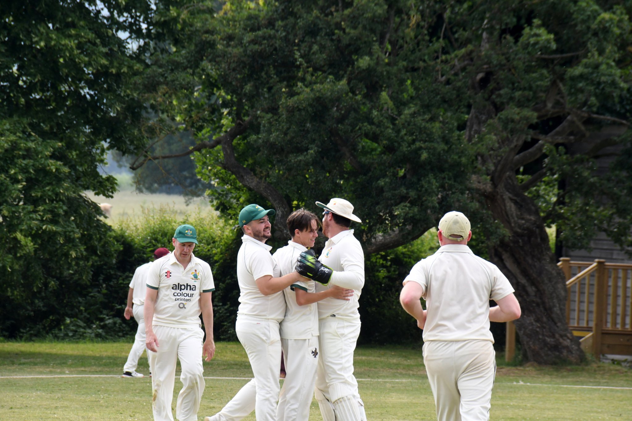 Dev Rogers (centre) is congratulated after taking his second wicket.