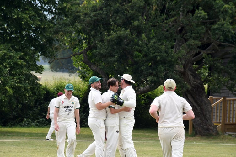 Dev Rogers (centre) is congratulated after taking his second wicket.