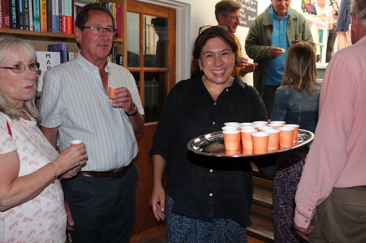 Bookery manager Dee Lalljee carrying a tray of cups of champagne. SR 8081