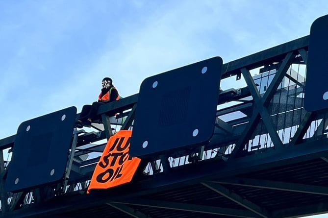 A Just Stop Oil protester on a gantry over the M25 in Surrey