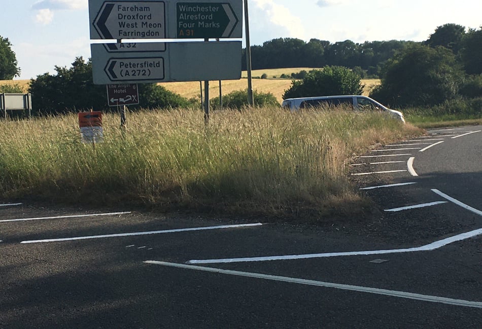 <p>A tall people carrier-type vehicle is almost totally obscured by grass as it waits to join the A31 from the A32 at the Chawton roundabout last Thursday evening</p>