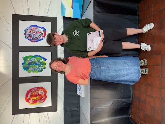 Hannah Hayhurst won the Year 13 art prize for Outstanding Work. She's pictured in front of her work with Eve Adams from sponsor Art Squared