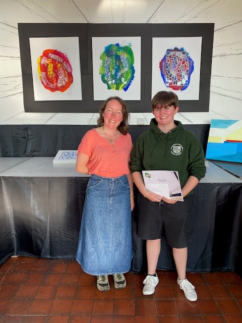 Hannah Hayhurst won the Year 13 art prize for Outstanding Work. She's pictured in front of her work with Eve Adams from sponsor Art Squared