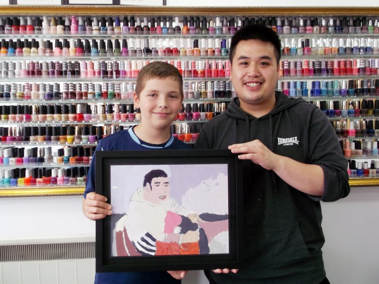Mylo Acevedo-Scott with his portrait of Tom Luu from VIP Nails in Petersfield