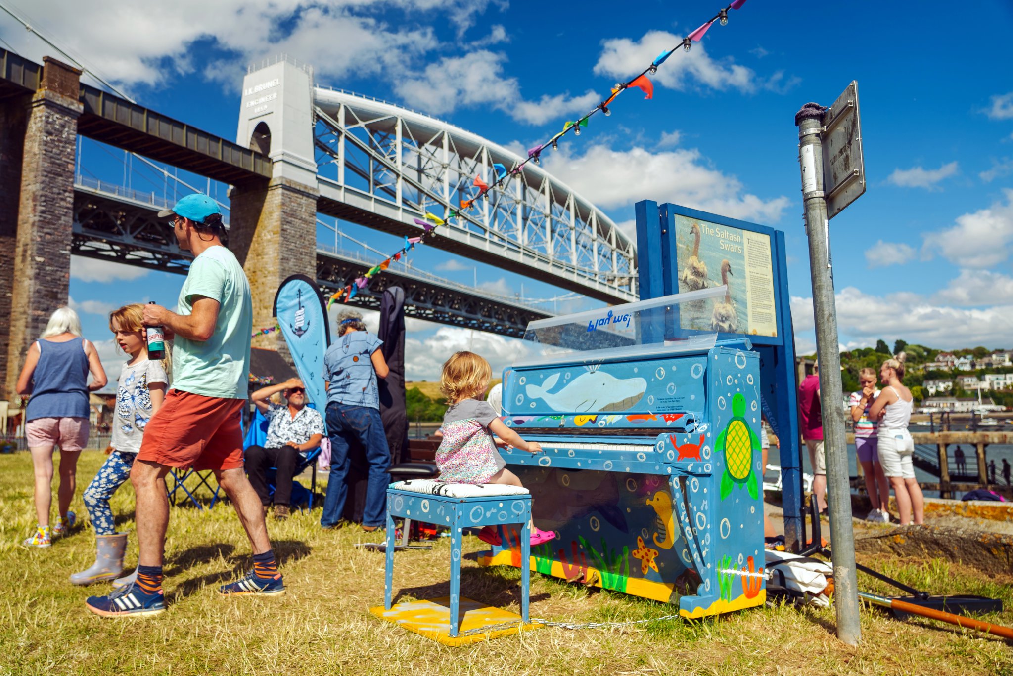 A visitor having a go on the waterside piano. Photos are credited to Mostly Film Productions