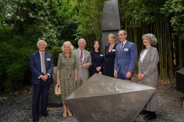 Their Majesties The King and Queen with (left to right) Sir Anthony Salz (Chair of Tate St Ives), Anne Barlow (Director of Tate St Ives), Dame Jayne-Anne Gadhia (Trustee of Tate), Roland Rudd (Chair of Tate) and Dr Sophie Bowness (Barbara Hepworth’s granddaughter) standing among Barbara Hepworth’s Conversation with Magic Stones at the Barbara Hepworth Museum and Sculpture Garden in St Ives