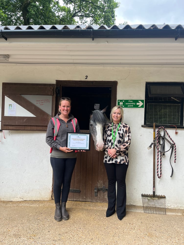 Treloar's supported internship co-ordinator Charlotte Mills presents a certificate to Broadlands Riding for the Disabled in Medstead, July 2023.