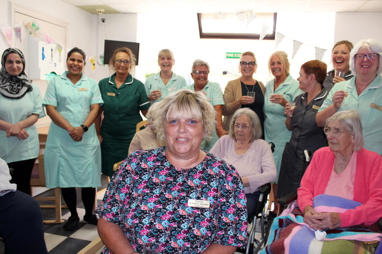 Sharon seated with other staff and a few residents. SR 8274