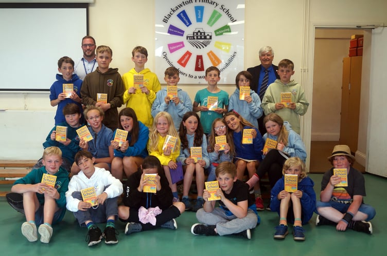 2. Blackawton Primary School children and their books with Rotarian Hilary Bastone (right) and headteacher Liam Fielding (left).