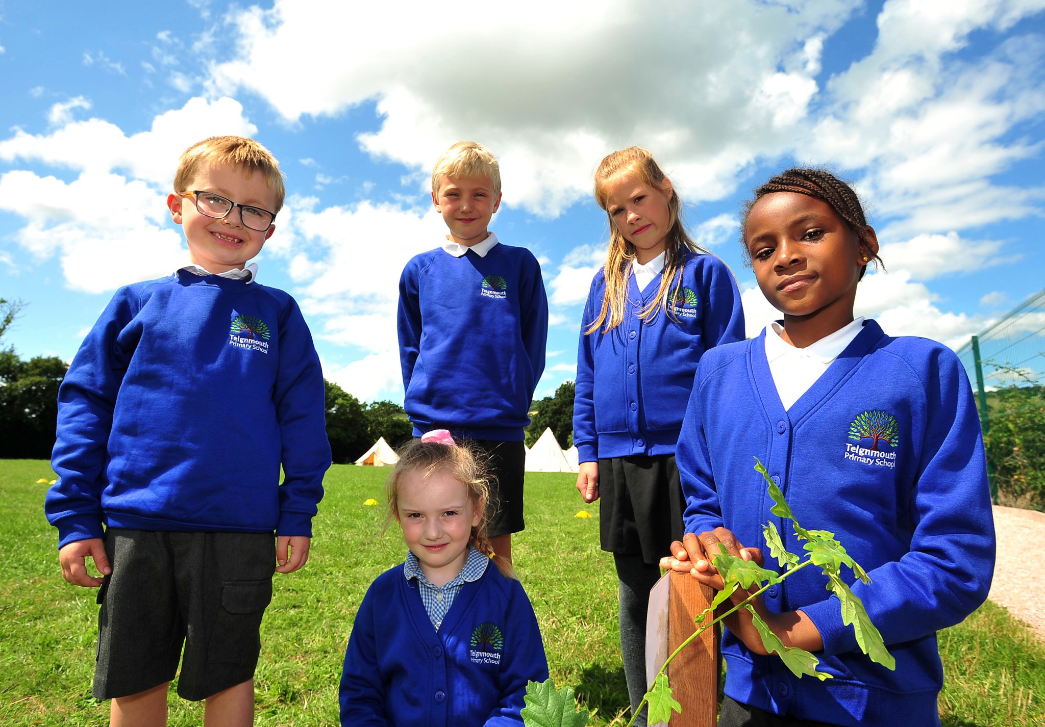 Teignmouth Primary School. 50th anniversary tree planting. Showing off their new Teignmouth Primary School jumpers - pupils Rory, Lottie-Mai, Freddie, Erin and Audrey.