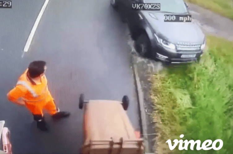 A Biffa worker looks on as a 4x4 attempts to undertake a bin lorry in Cranleigh