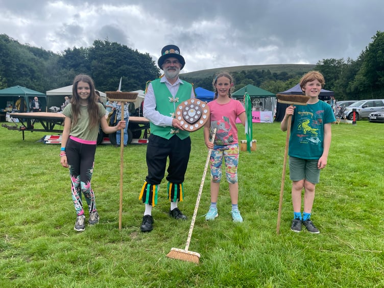 David Minty, Squire Elect, Exeter Morris, presented Dorothy Parker-Groom (11), with the award for winning the Dartmoor Broom Dance Championship, pictured with the runners-up.  AQ 4275