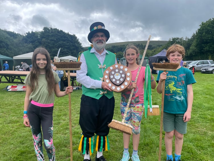 David Minty, Squire Elect, Exeter Morris, presented Dorothy Parker-Groom (11), with the award for winning the Dartmoor Broom Dance Championship, pictured with the runners-up. AQ 4282