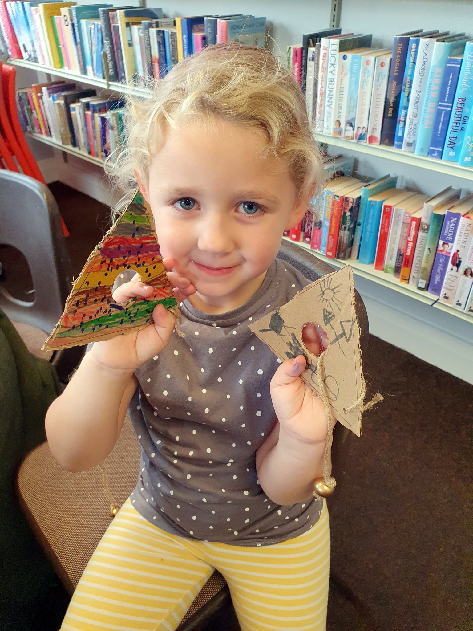 A child with a ball and triangle game she made at Crediton Library.