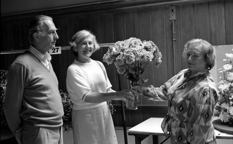 A vase of Frensham floribunda roses wins plenty of admirers at the 1985 summer show