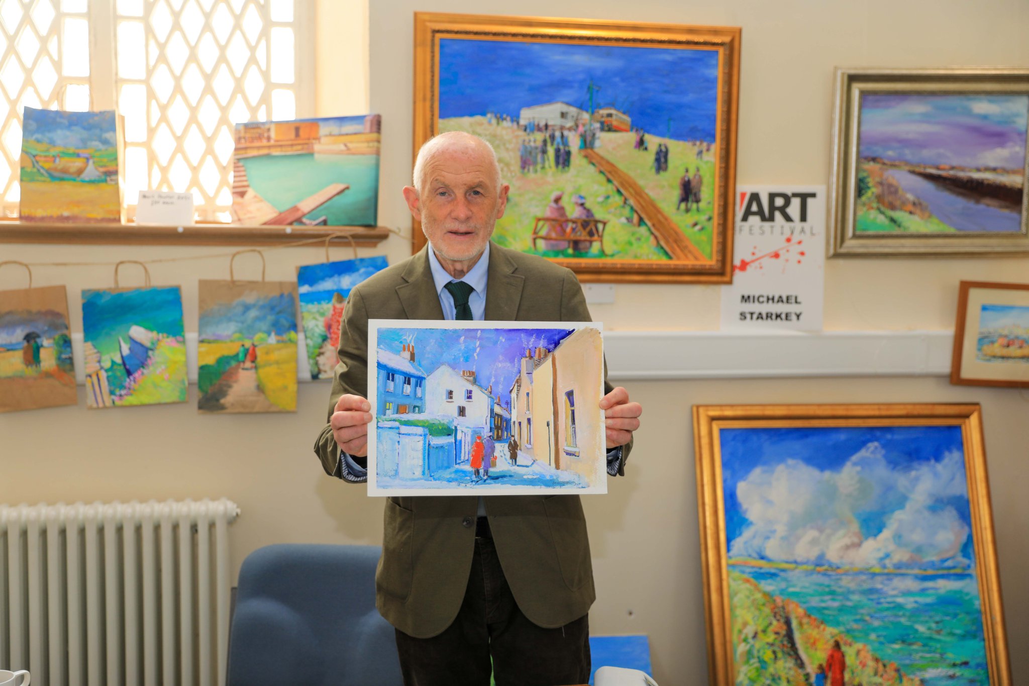 Michael Starkey with his paintings at the Isle of Man Art Festival held at Quayle's Hall. Photo by Callum Staley (CJS Photography)